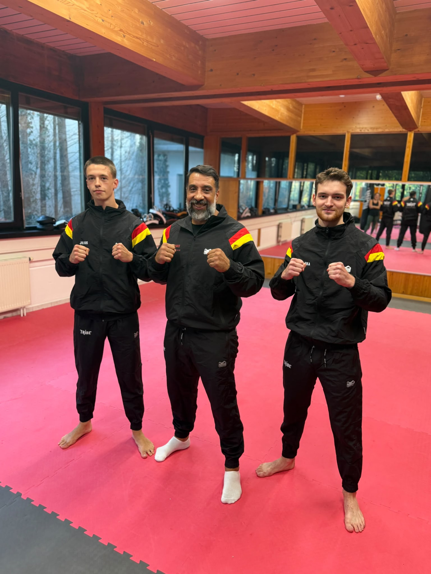 Head Coach Denis in der Mitte mit seinen beiden Assistenztrainern auf der Trainingsmatte