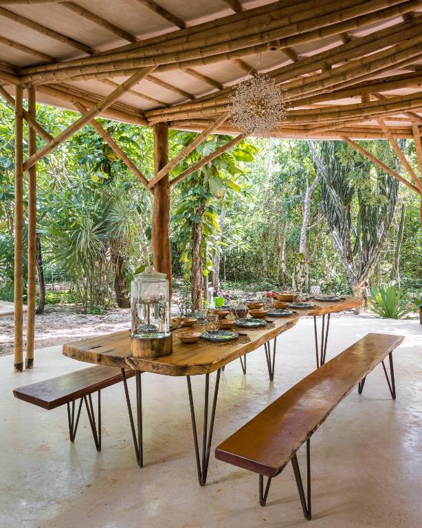 Open-Air Dining Pavilion im Awakening Sanctuary Yucatán mit langem Holztisch und Dschungelblick