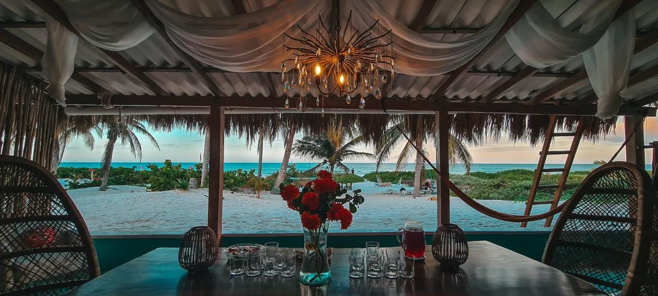 View from the palapa terrace of the Awakening Beach House over hammocks and palms onto the Gulf of Mexico