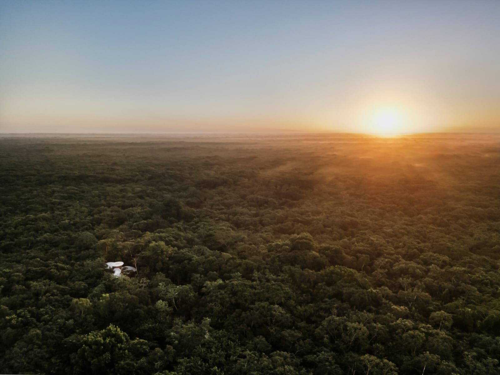 Sunrise over the endless Yucatán jungle with the Awakening Sanctuary in the distance